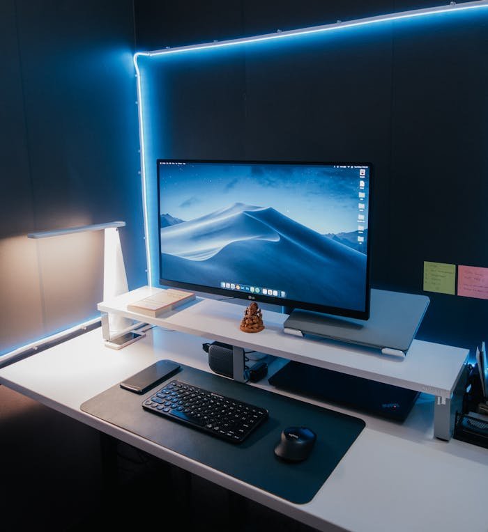 A sleek computer desk setup with LED lighting and a modern aesthetic.